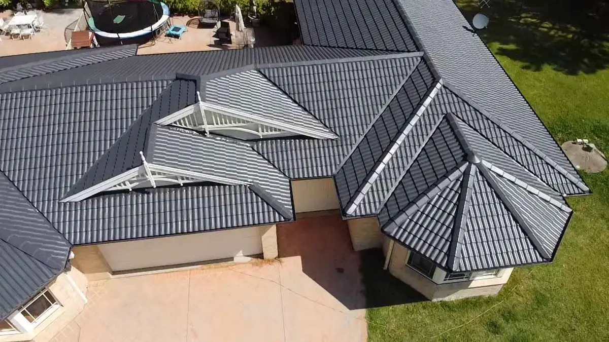 Close aerial view of a restored charcoal tile roof with white gable trim