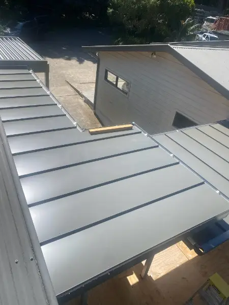 Close view of dark flat pan metal roof panels over an outdoor area