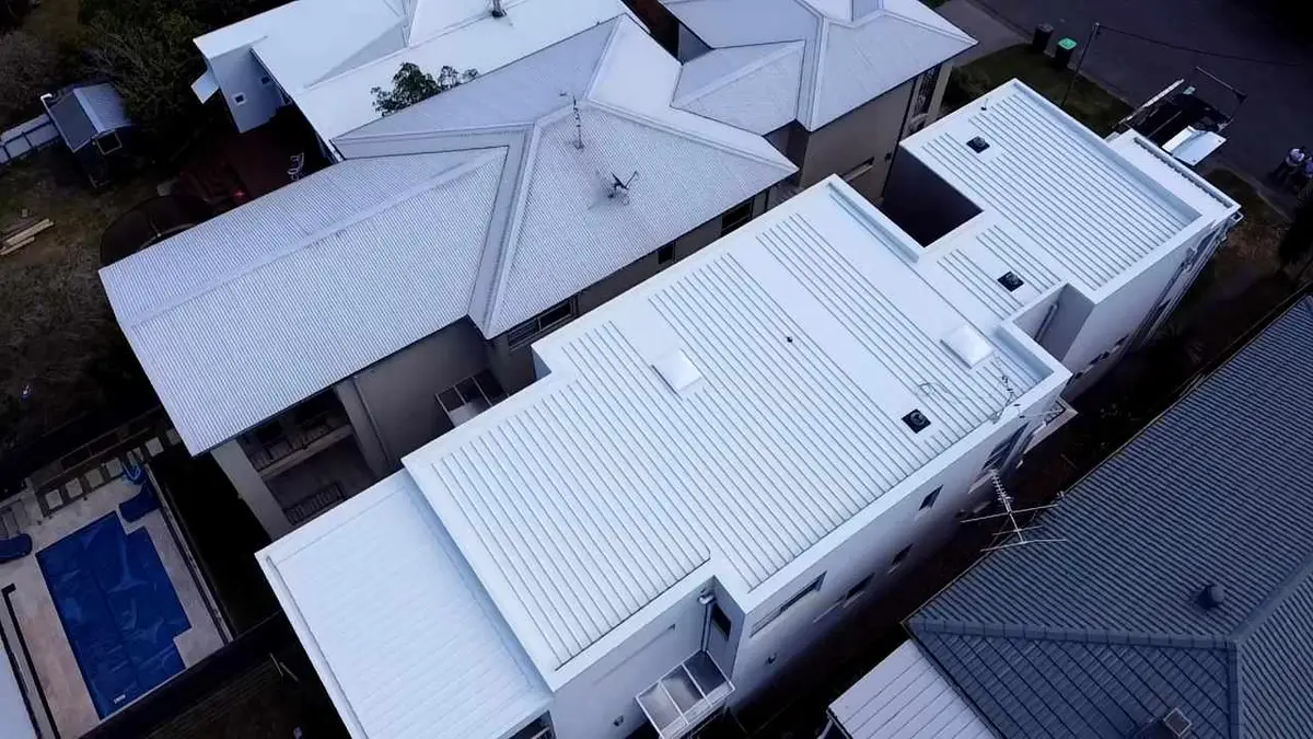 Aerial view of townhouses with new white flat pan metal roofs