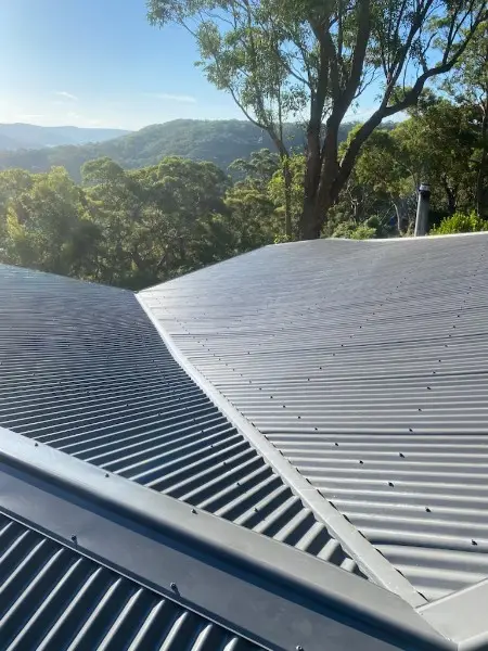 Grey metal roof valley with bushland and hills in the background