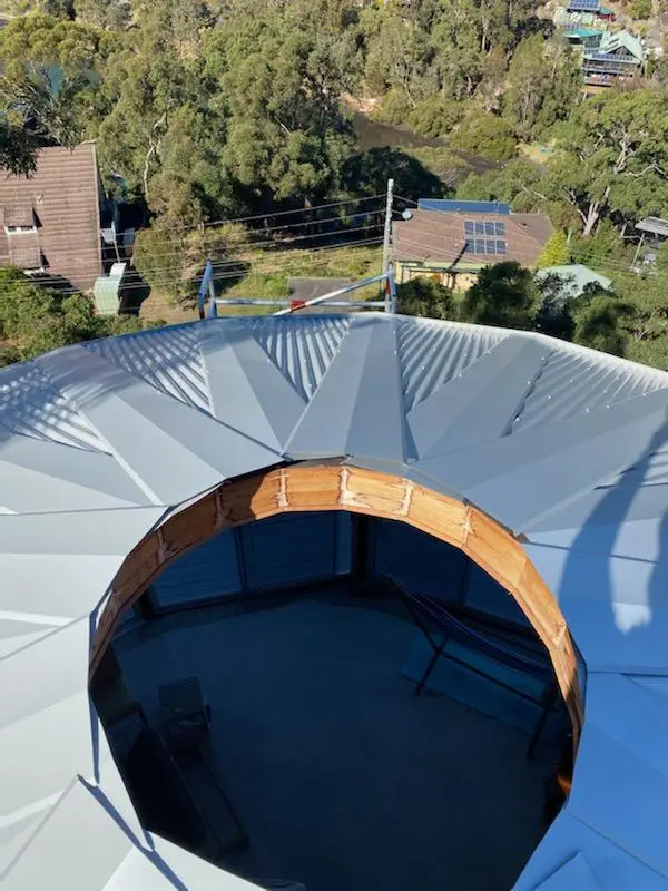 Octagonal metal roof mid installation, with the central skylight opening framed and not yet capped