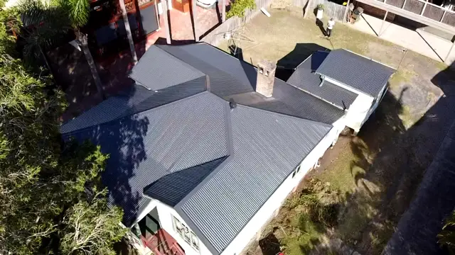 Aerial view of a weatherboard home in Terrigal with a new Monument metal roof and brick chimney