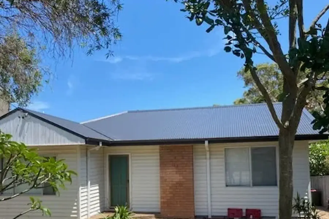 Single storey weatherboard home on the Central Coast with a new dark metal roof