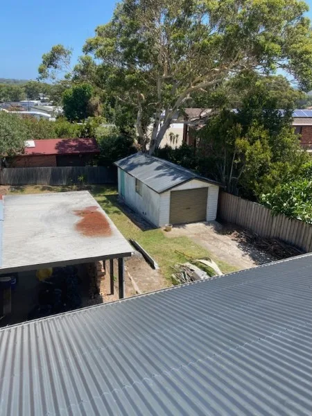 Completed metal roof above a Central Coast backyard — Roof Restorations & Replacements Central Coast